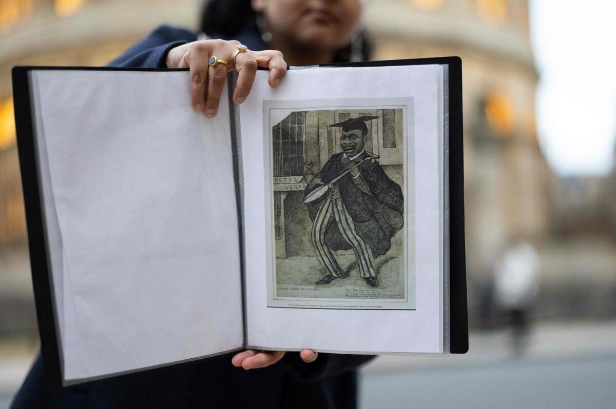 Tour guide Devika shows a picture of Christian Cole to a group of people attending an 'Uncomfortable Oxford' tour outside the Sheldonian Theatre on Broad Street, in Oxford, on October 20, 2023. — AFO
