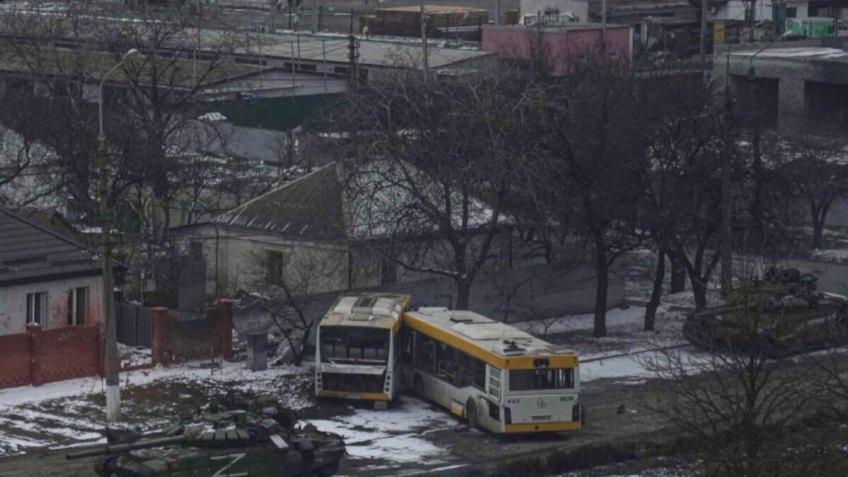 ]Russian army tanks move down a street on the outskirts of Mariupol. — AP
