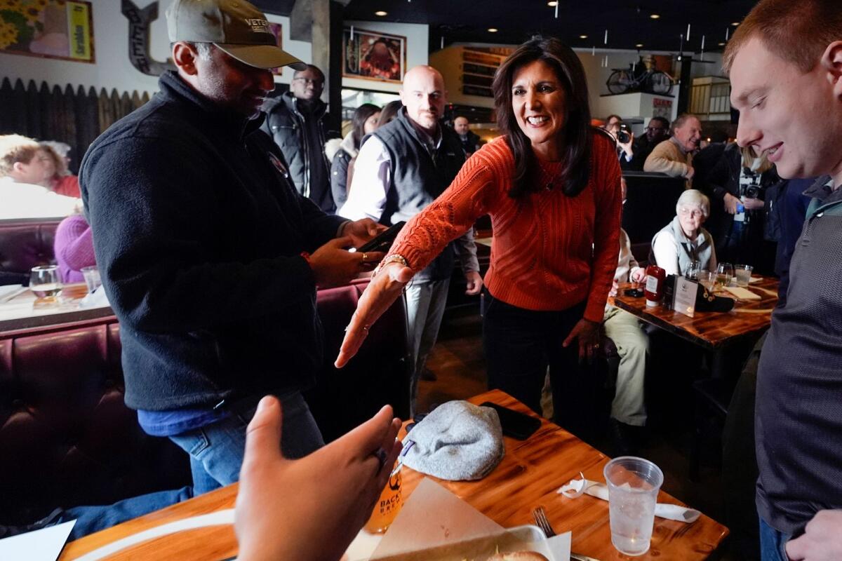 Republican presidential candidate former UN Ambassador Nikki Haley shakes hands with a patron during a campaign stop at a brewery on January 22, 2024 in Manchester, New Hampshire. — AP