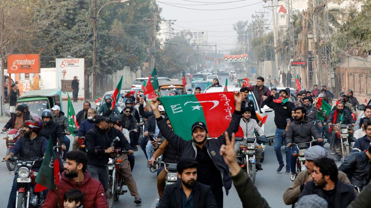 Supporters of former Prime Minister Imran Khan wave flags during a rally ahead of the general elections in Lahore. — Reuters