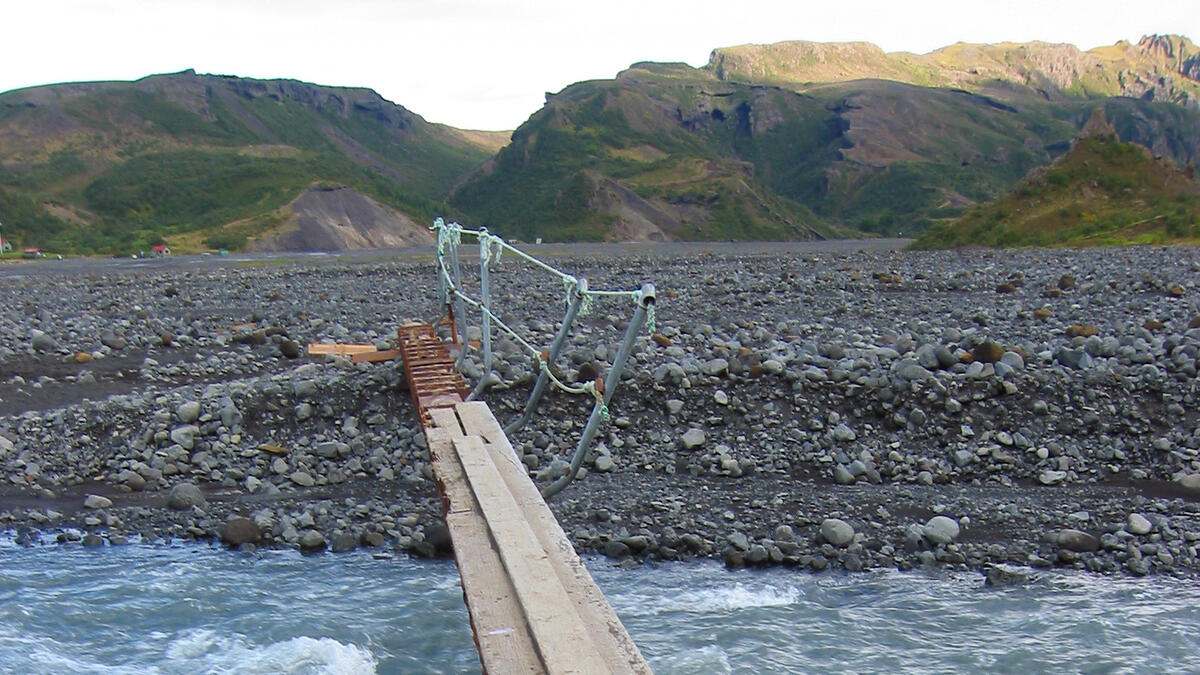 A bilingual sign warns about the perils of this rudimentary glacial river crossing