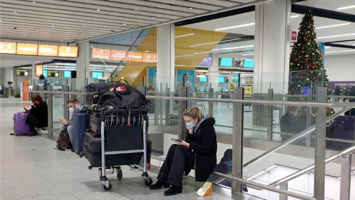 Passengers wait at Gatwick Airport in West Sussex, England, on Sunday after several European Union nations  banned flights from the UK in a bid to block a new strain of coronavirus sweeping across southern England. — AP