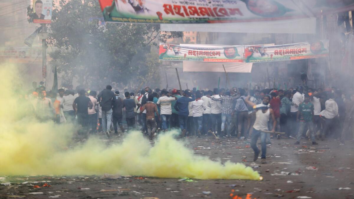 Activists of the Bangladesh Nationalist Party run from tear gas shell fired by police during a protest in Dhaka. — AP