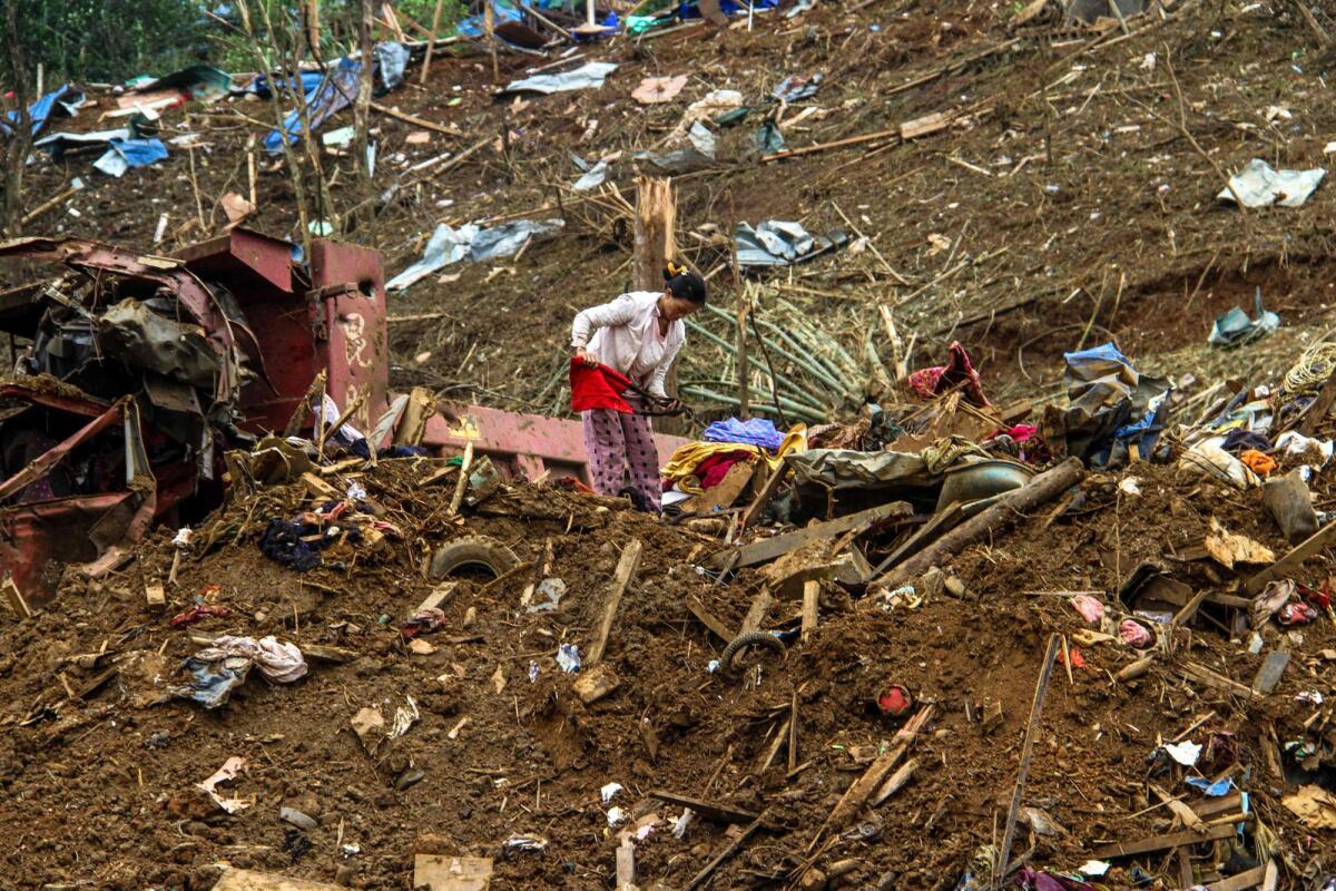 A woman looks through debris in the aftermath of military strike on a camp for displaced people near the northern Myanmar town of Laiza on Wednesday, two days after the assault that killed 29 people and wounded dozens. — AFP
