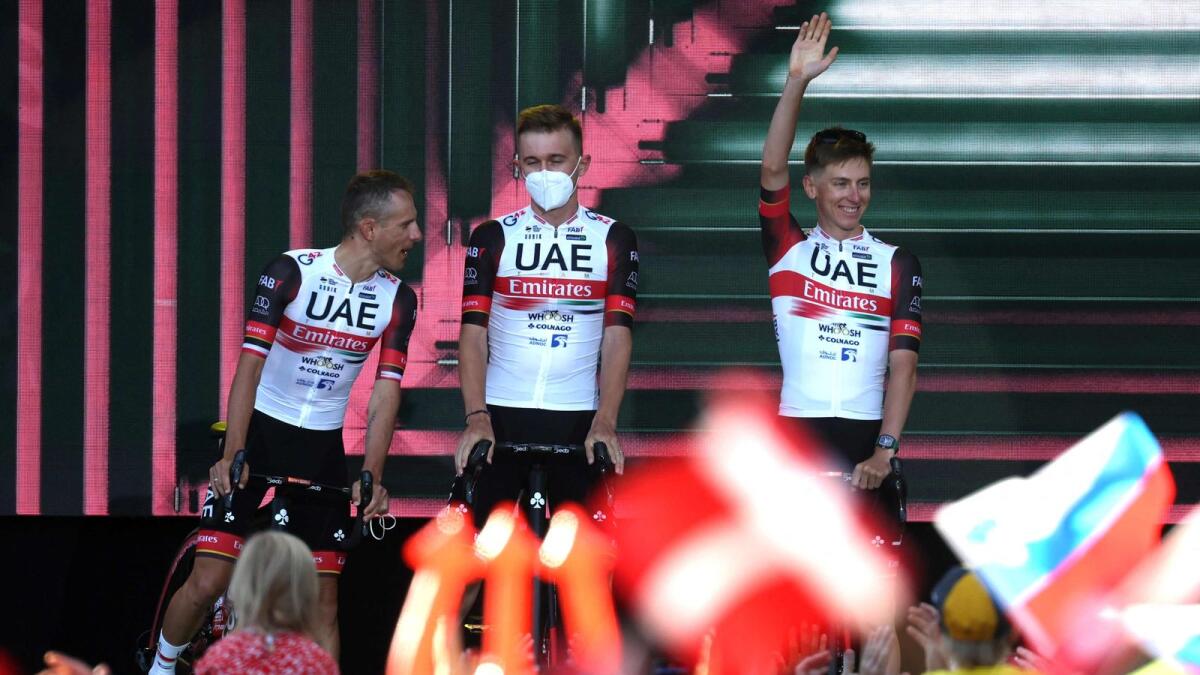 UAE Team Emirates' Tadej Pogacar (right), flanked by teammates, waves as he attends the teams' presentation in Copenhagen. (AFP)