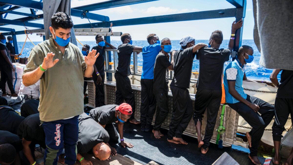 Migrants onboard the Sea-Watch 4 civil sea rescue ship pray on the ship off the coast of Malta. The Sea-Watch 4 is seeking for a safe harbour for its passengers. Within 48 hours, the crew of the Sea-Watch 4 has rescued more than 200 people. Photo: AFP