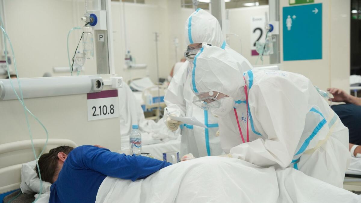 Medical specialists wearing personal protective equipment (PPE) take care of a patient at the temporary hospital set up in the automobile shopping centre, amid the outbreak of the coronavirus disease (COVID-19) in Moscow, Russia, in this picture released October 30, 2020.