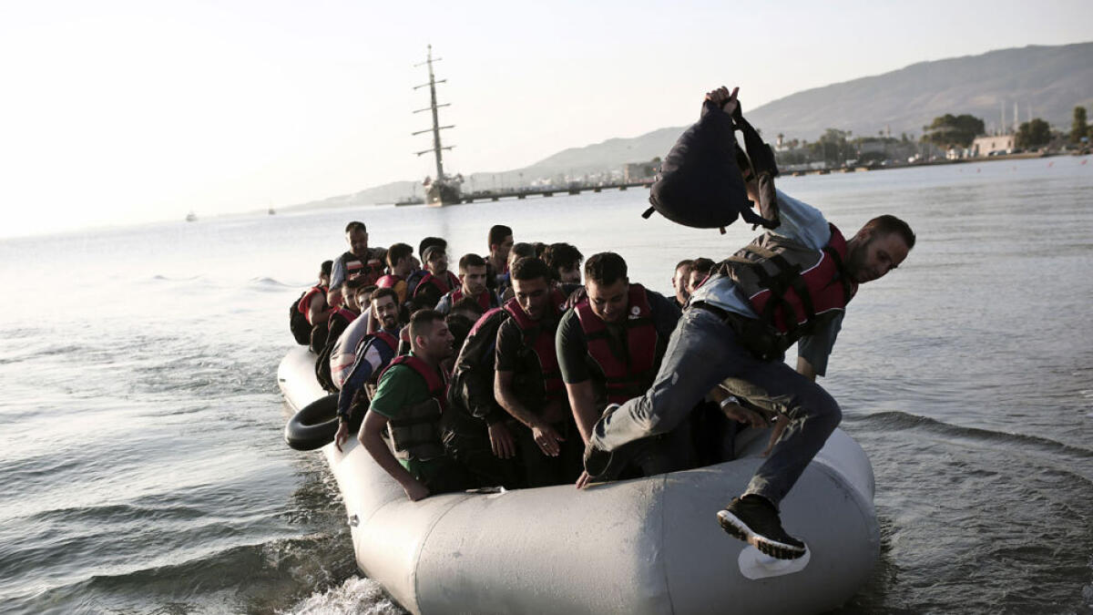 Migrants arrive after crossing the Aegean sea between Turkey and Greece at a beach on the Greek island of Kos.