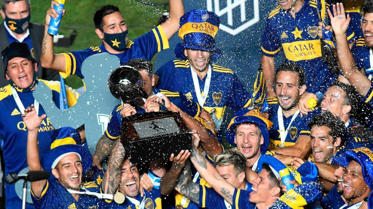 Boca Juniors' Carlos Tevez and teammates celebrate with the trophy. — Reuters