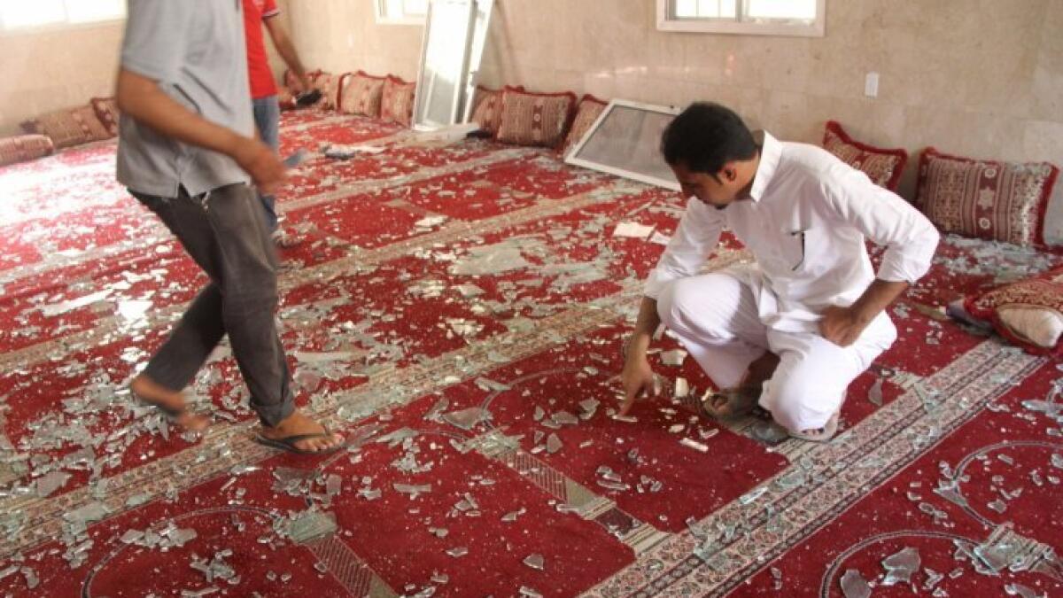 People examine the debris after a suicide bomb attack at the Imam Ali mosque in the village of al-Qadeeh in the eastern province of Gatif, Saudi Arabia