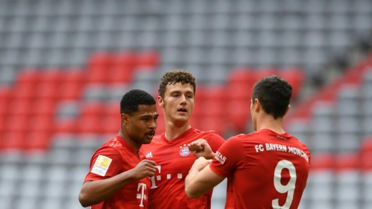 Bayern Munich striker Robert Lewandowski (right) celebrates with defender Benjamin Pavard (centre) and winger Serge Gnabry. - AFP