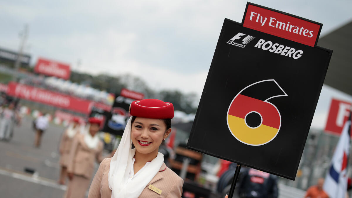 A woman shows a signboard for Mercedes AMG Petronas F1 Team's German driver Nico Rosberg at the starting grid before the Formula One Japanese Grand Prix at the Suzuka Circuit on October 9, 2016. AFP