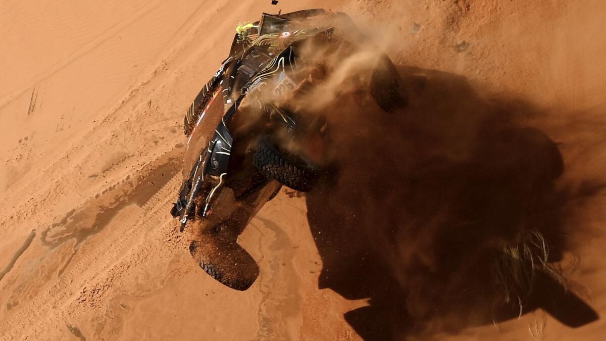 French driver Guerlain Chicherit and co-driver Alex Winocq crash their buggy during Stage 4 of the Dakar on Wednesday. — AFP