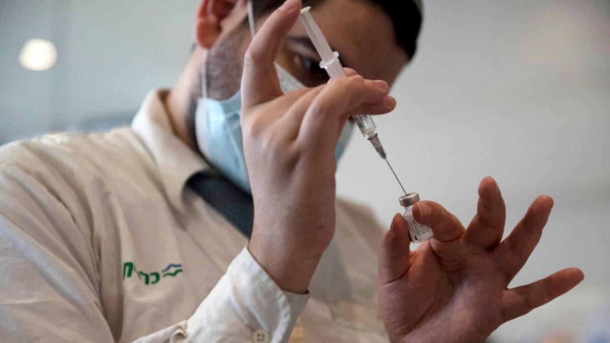 A medical worker prepares a vial of the Pfizer coronavirus vaccine in Jerusalem. — AP file