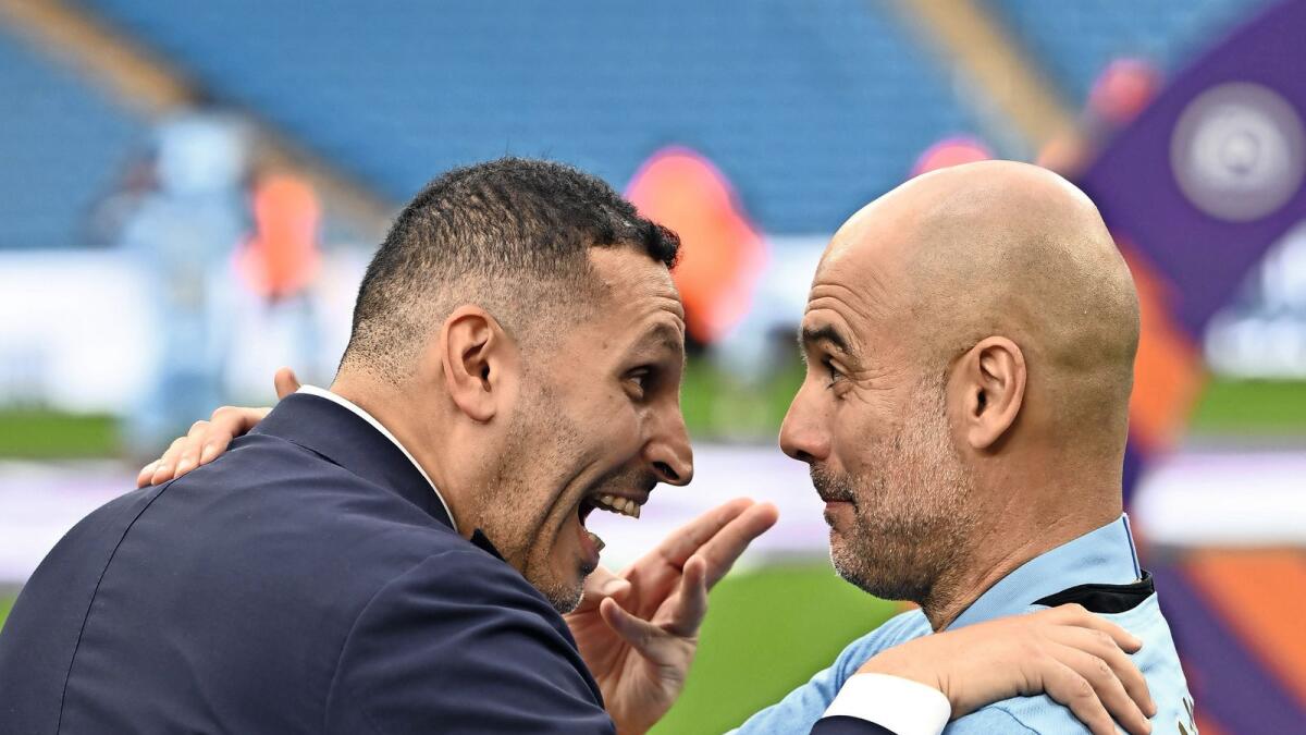 Manchester City chairman Khaldoon Al Mubarak (left) speaks to manager Pep Guardiola. — AFP
