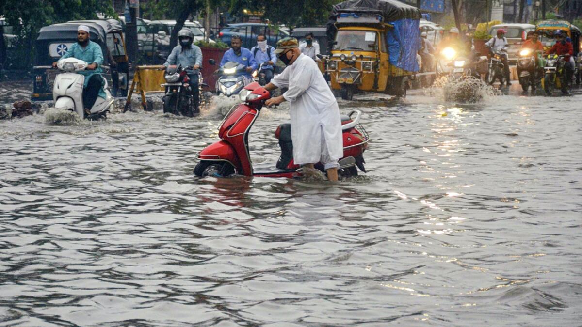 Commuters move through a waterlogged street after heavy rain in Bhopal, India. Photo: PTI