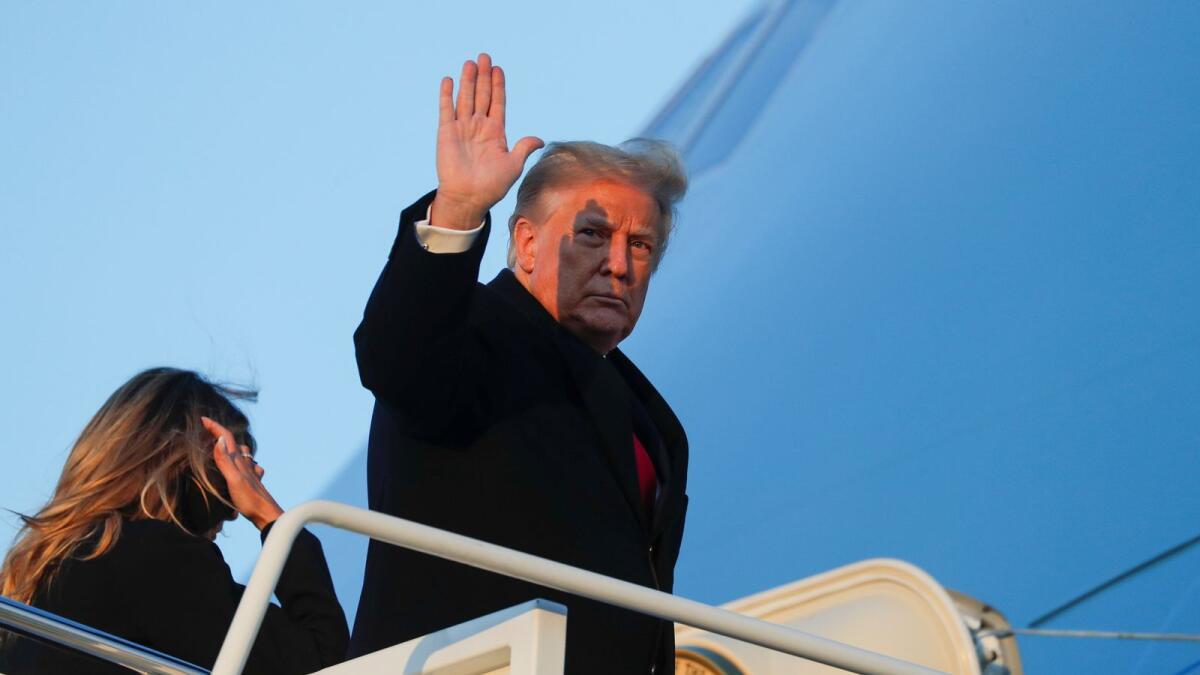 U.S. President Donald Trump waves as he boards Air Force One beside first lady Melania Trump at Joint Base Andrews in Maryland, U.S., December 23, 2020.