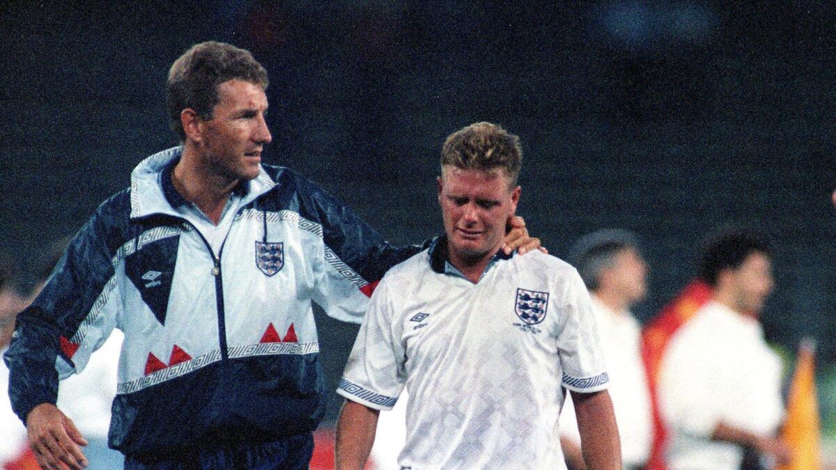 England's Paul Gascoigne cries as he is escorted off the field by team captain Terry Butcher, after England lost a penalty shoot-out in the semi-final match of the World Cup against West Germany in 1990. - AP file