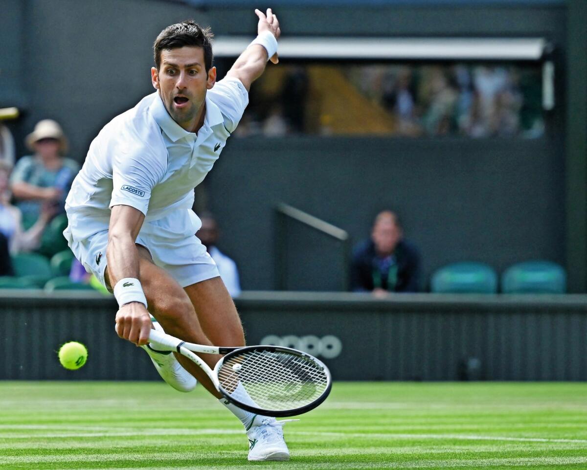 Serbia's Novak Djokovic returns the ball to Miomir Kecmanovic at Wimbledon on Friday. — AFP