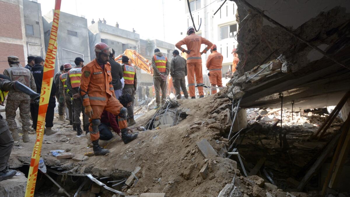 Rescue workers conduct an operation to clear the rubble and search for bodies at the site of a suicide bombing in Peshawar on Tuesday. — AP