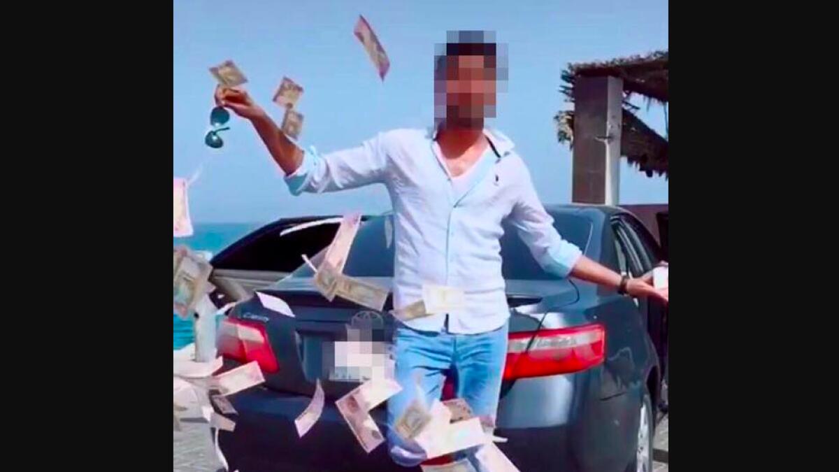 Dubai Police, man throws money, social media, Asian arrested for throwing money