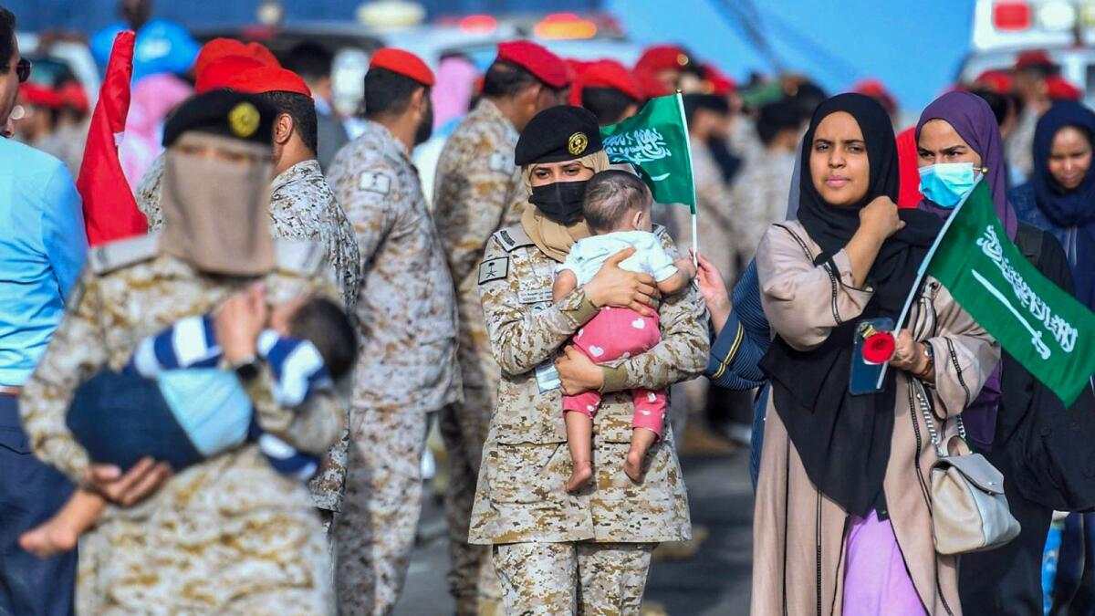 Saudi Navy sailors helping evacuees upon arrival at King Faisal Navy Base in Jeddah on on Wednesday following a rescue operation from Sudan.— AFP