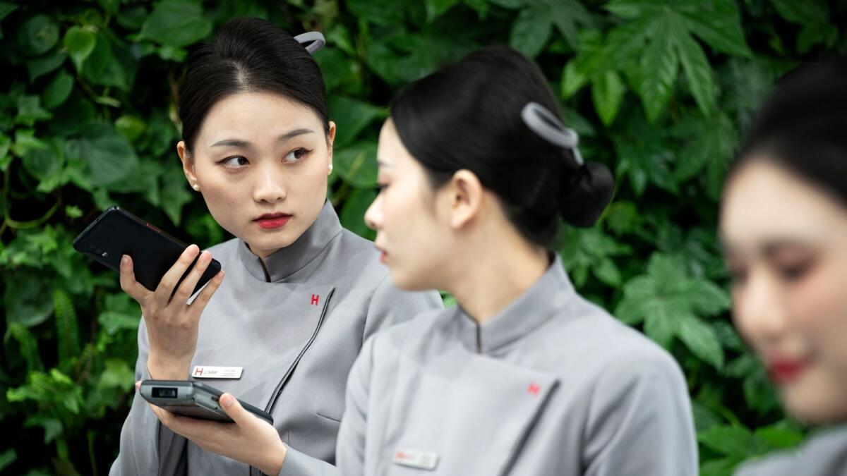 A Huawei worker holds a mobile phone during the Mobile World Congress 2023 in Barcelona, on Monday, February 27, 2023. — AP