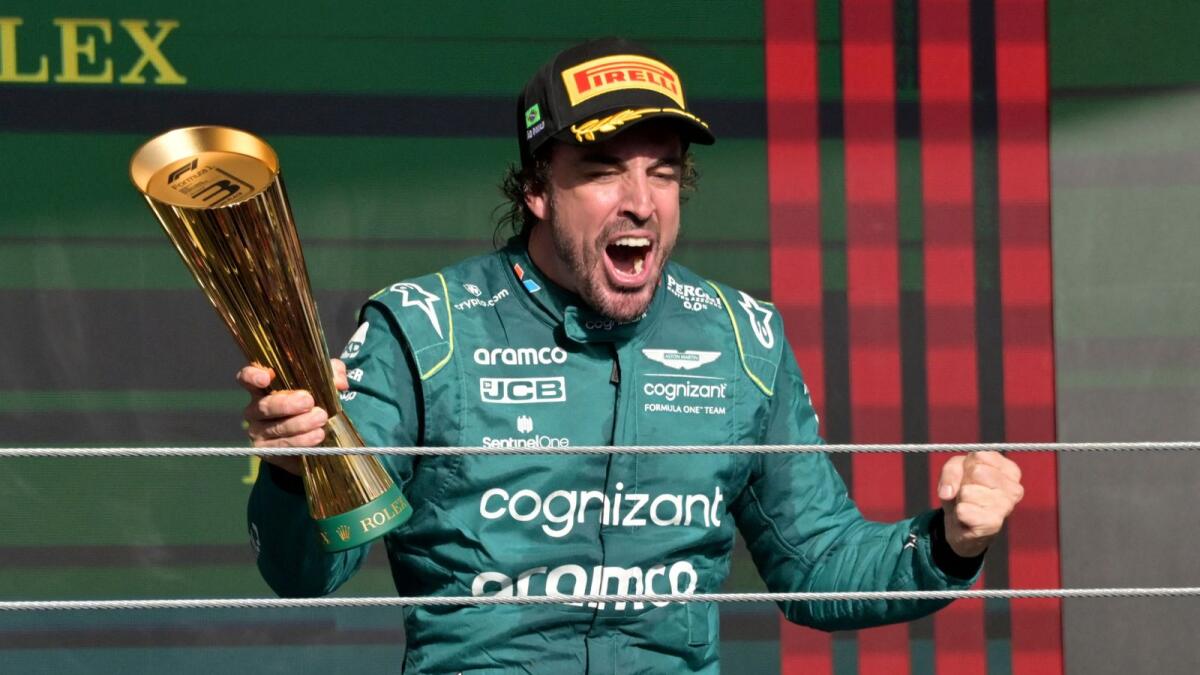 Aston Martin's Spanish driver Fernando Alonso celebrates on the podium after the Formula One Brazil Grand Prix. - AFP File