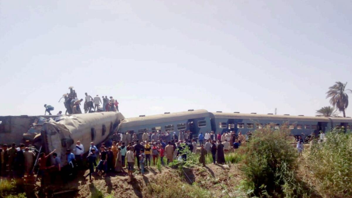 People inspect the damage after two trains have collided near the city of Sohag in Egypt. — Reuters