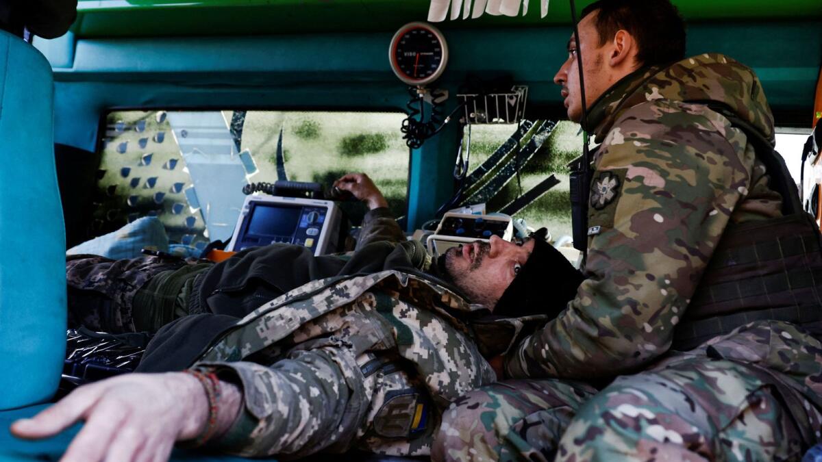 A wounded Ukrainian soldier reacts as he is treated by medics inside a frontline stabilisation ambulance in an undisclosed location near the frontline town of Kreminna. — Reuters