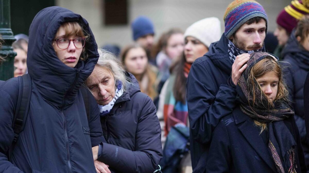 Mourners stand outside the headquarters of Charles University after mass shooting. — AP