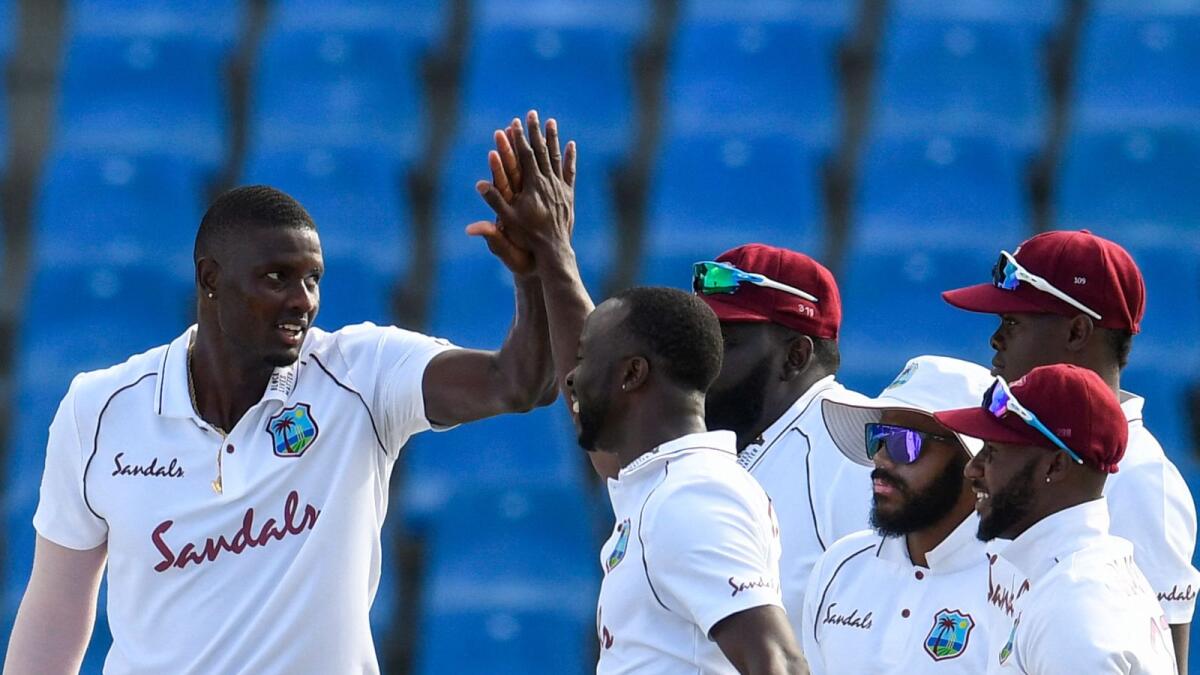 Jason Holder (left) of the West Indies celebrates the dismissal of Lahiru Thirimanne of Sri Lanka during day 1 of the 1st Test. — AFP