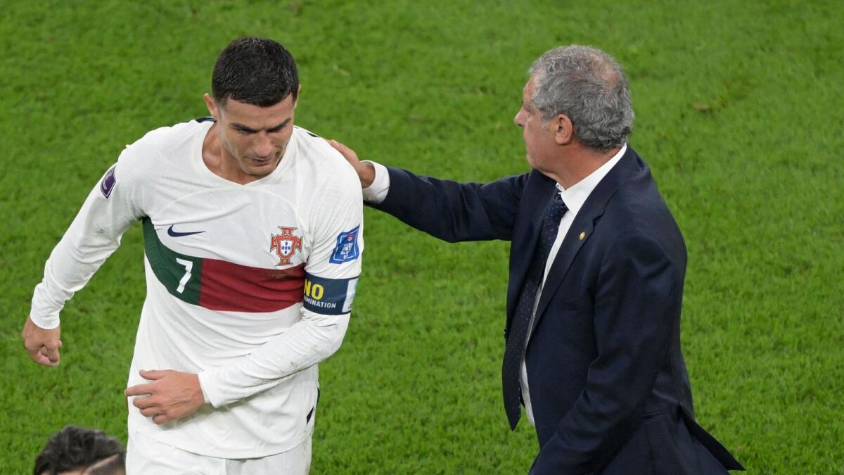 Fernando Santos pats Portugal's Cristiano Ronaldo on his back as he leaves the field after losing to Morocco 1-0. — AFP