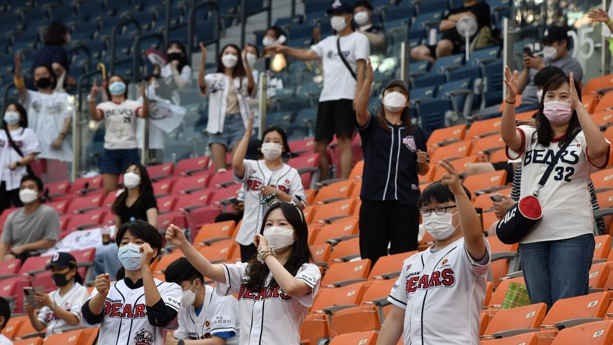 Baseball fans cheer as they observe social distancing during the KBO league baseball game between Seoul-based Doosan Bears and LG Twins at Jamsil stadium in Seoul