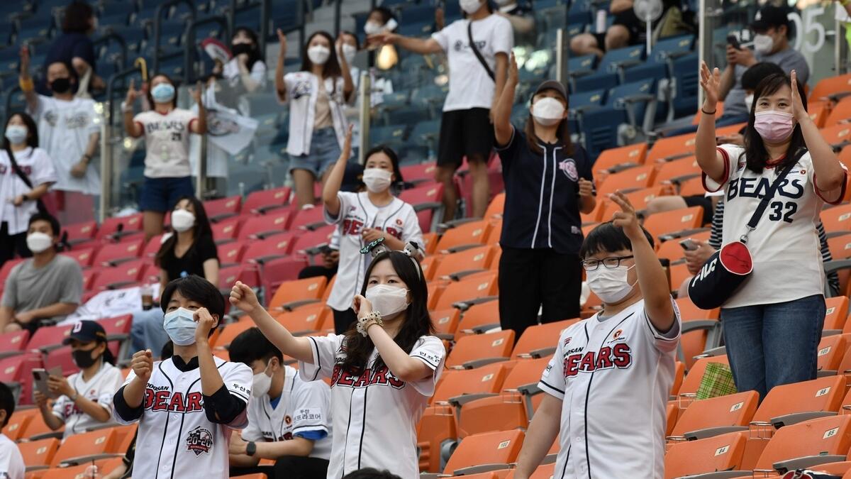 Baseball fans cheer as they observe social distancing during the KBO league baseball game between Seoul-based Doosan Bears and LG Twins at Jamsil stadium in Seoul