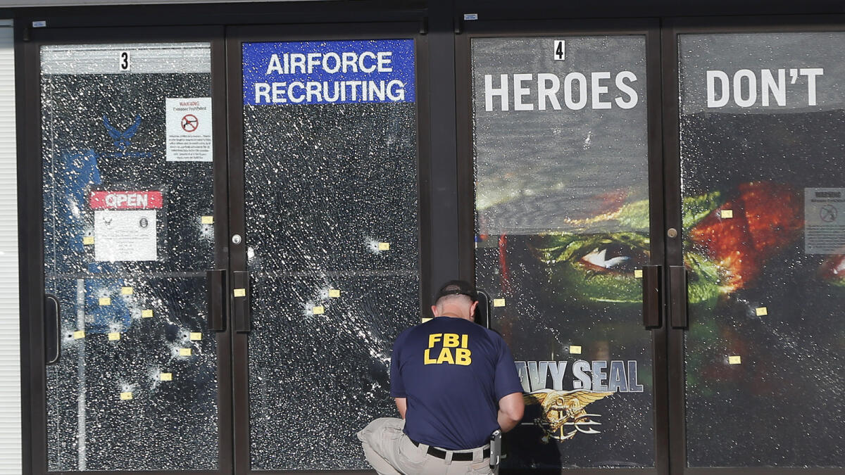 An FBI investigator investigates the scene of a shooting outside a military recruiting center on Friday, July 17, 2015, in Chattanooga, Tenn. Muhammad Youssef Abdulazeez of Hixson, Tenn.,  attacked two military facilities on Thursday, in a shooting rampage that killed four Marines. (AP Photo/John Bazemore)