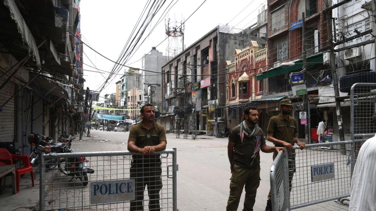 Police stand at a barricade at the entrance of a closed market in Lahore. Photo: AFP