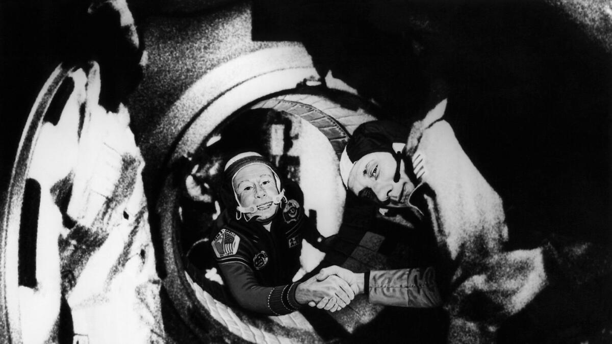 Alexei Leonov (L) and commander of the US crew of Apollo, Thomas Stafford, shake hands after the Apollo-Soyuz docking manoeuvres. — AFP file
