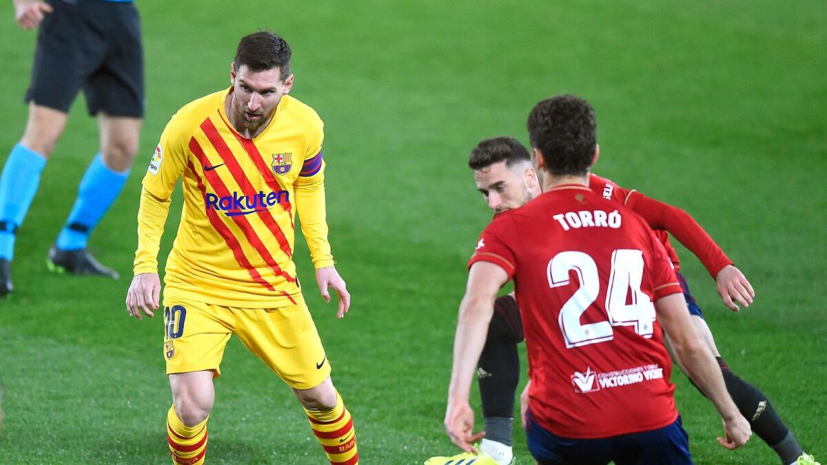 Barcelona's Lionel Messi (left) controls the ball during the Spanish League match against Osasuna. — AFP
