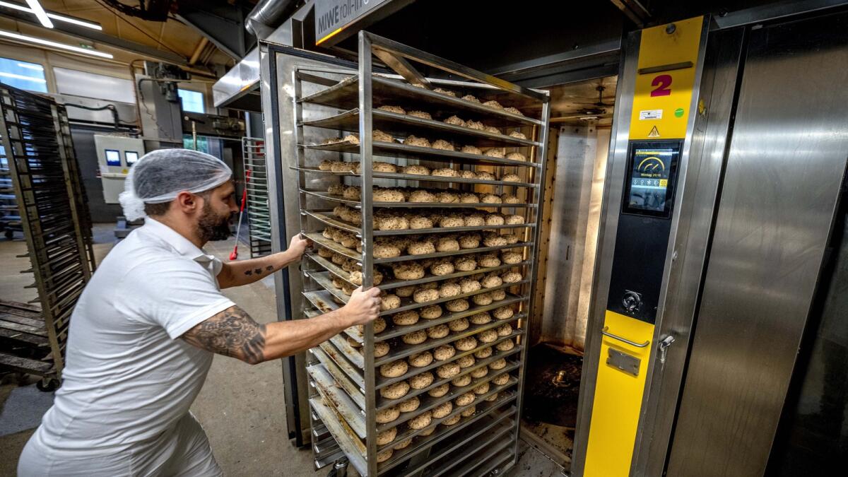 An employee pushes rolls into one of the gas heated ovens in the producing facility in Neu Isenburg, Germany.