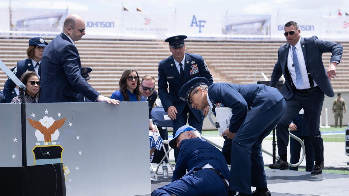US President Joe Biden is helped up after falling during the graduation ceremony at the US Air Force Academy, Colorado. — AFP