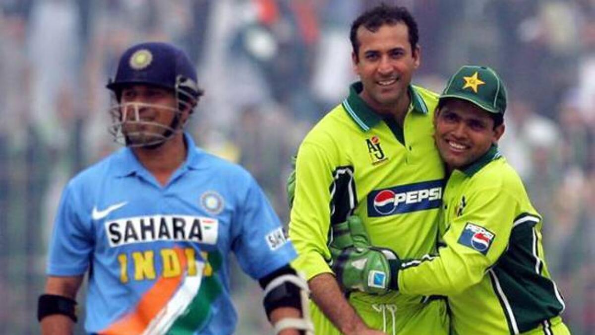 Arshad Khan is hugged by Kamran Akmal as Pakistan celebrates Tendulkar's wicket.