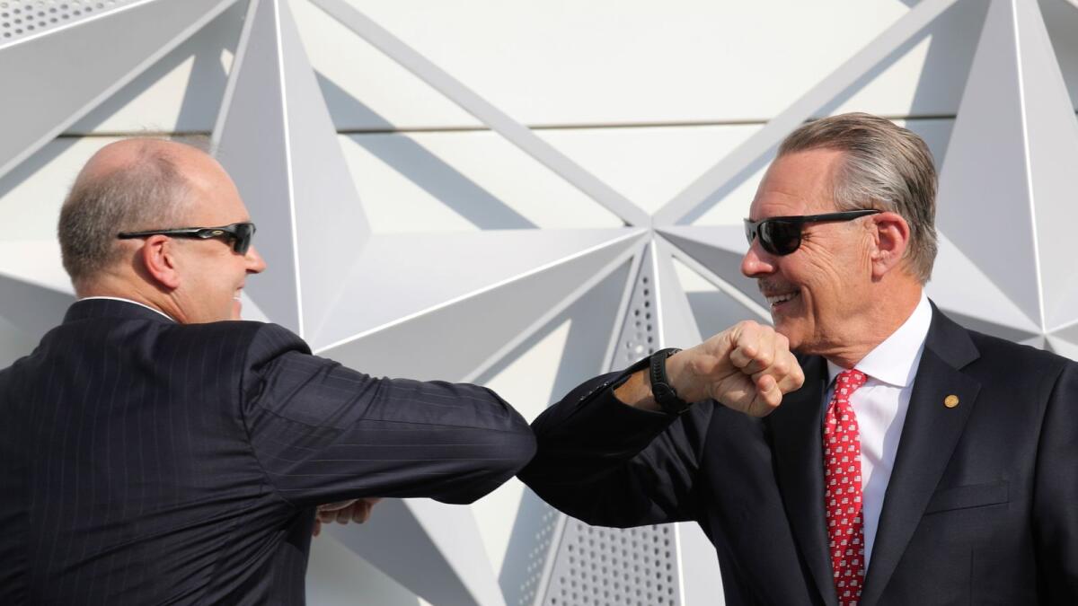US Ambassador John Rakolta, right, and US State Department Counselor Ulrich Brechbuhl, touch elbows after they fixed the last piece of star on the elevation during the USA Pavilion handover ceremony at the Dubai Expo 2020. AP