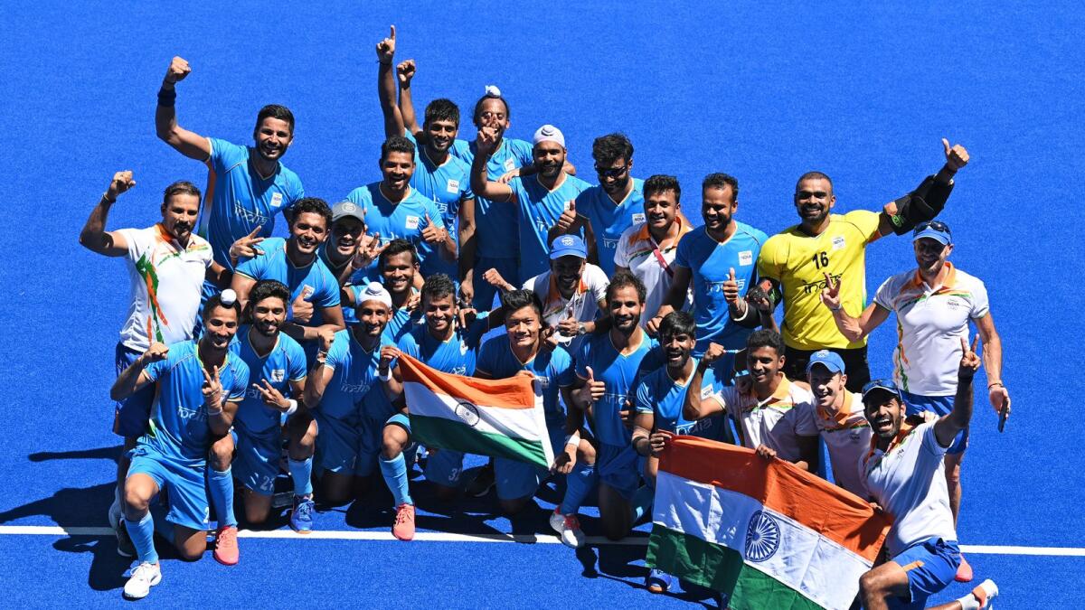 Indian hockey players pose for pictures as they celebrate their victory in the men's bronze medal match against Germany. (AFP)