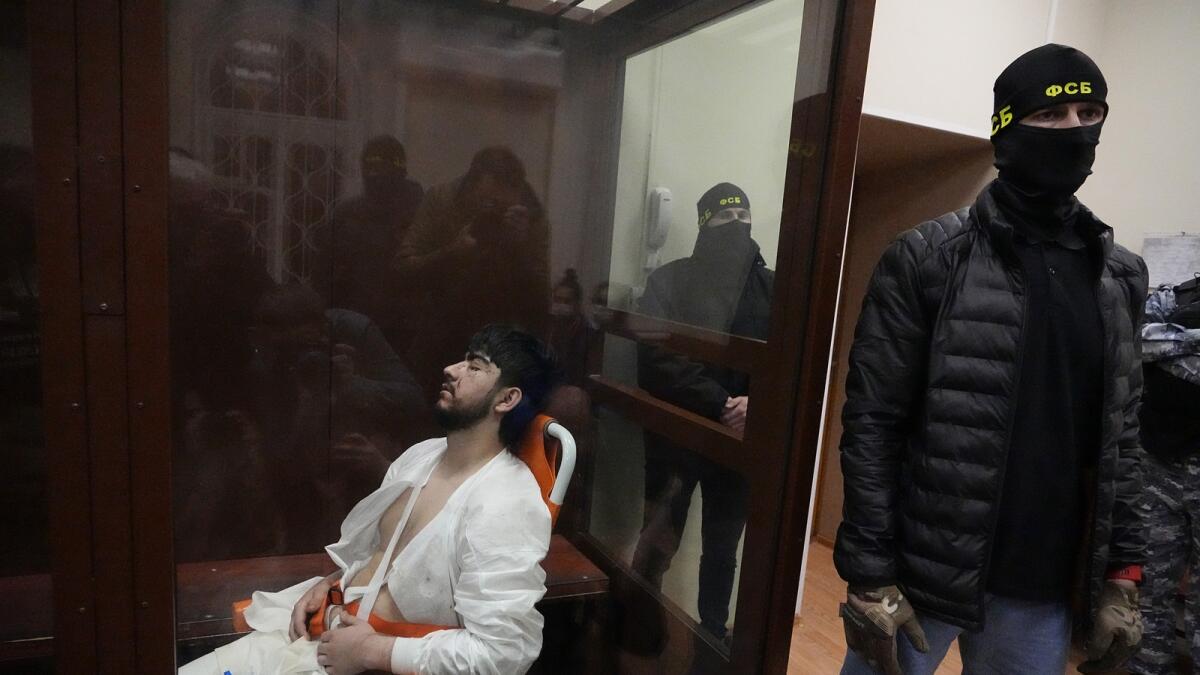 Mukhammadsobir Faizov, a suspect in Friday's shooting at the Crocus City Hall, sits in a glass cage in the Basmanny District Court in Moscow. — AP
