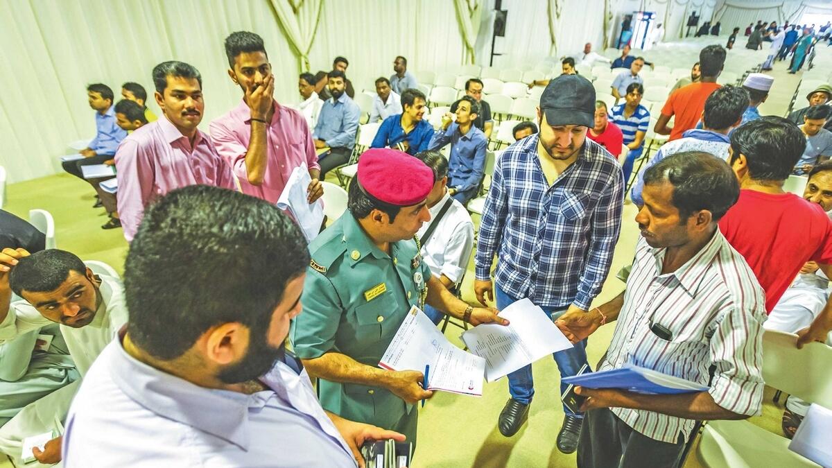 An officer assists amnesty-seekers at Al Aweer immigration centre tent in Dubai. The tent will be open to amnesty-seekers until October 31. — File photo