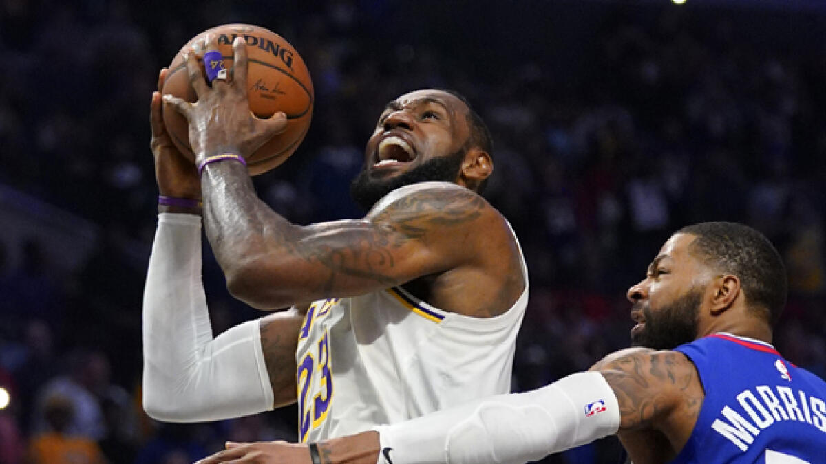 Lakers' forward LeBron James (left) shoots as Clippers' forward Marcus Morris defends during their NBA basketball game in Los Angeles. - AP file