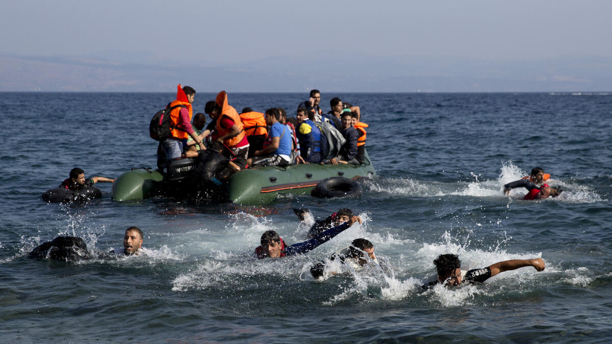 Migrant whose boat stalled at sea while crossing from Turkey to Greece swim to approach the shore of the island of Lesbos, Greece, Sunday, Sept. 20, 2015. AP photo