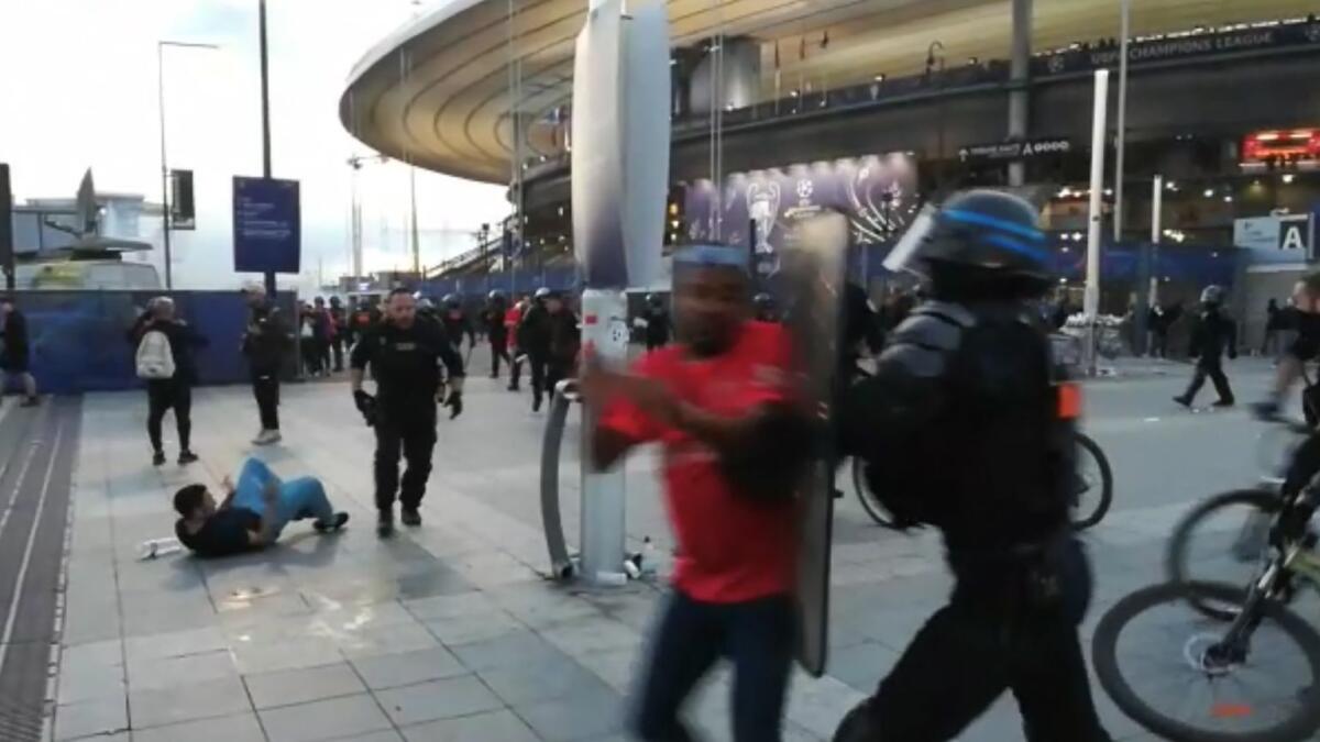 This grab taken from an AFP video shows the police intervening as fans climb the fence of the Stade de France before the UEFA Champions League final football match between Liverpool and Real Madrid.