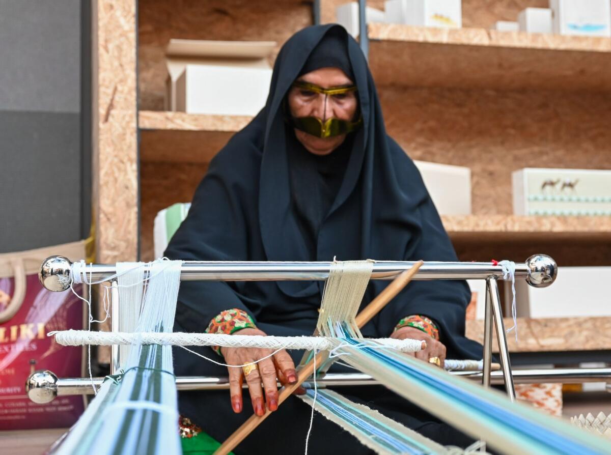 Emirati woman wearing burqa’a showcases traditional form of weaving. KT Photos: Muhammad Sajjad